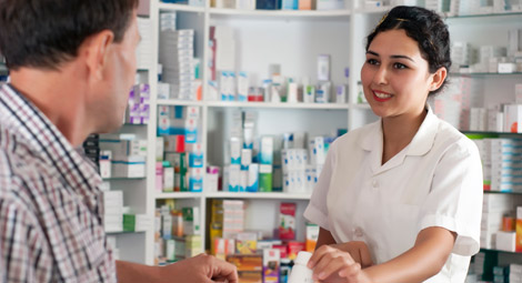 Female pharmacist handing prescription to a male patient